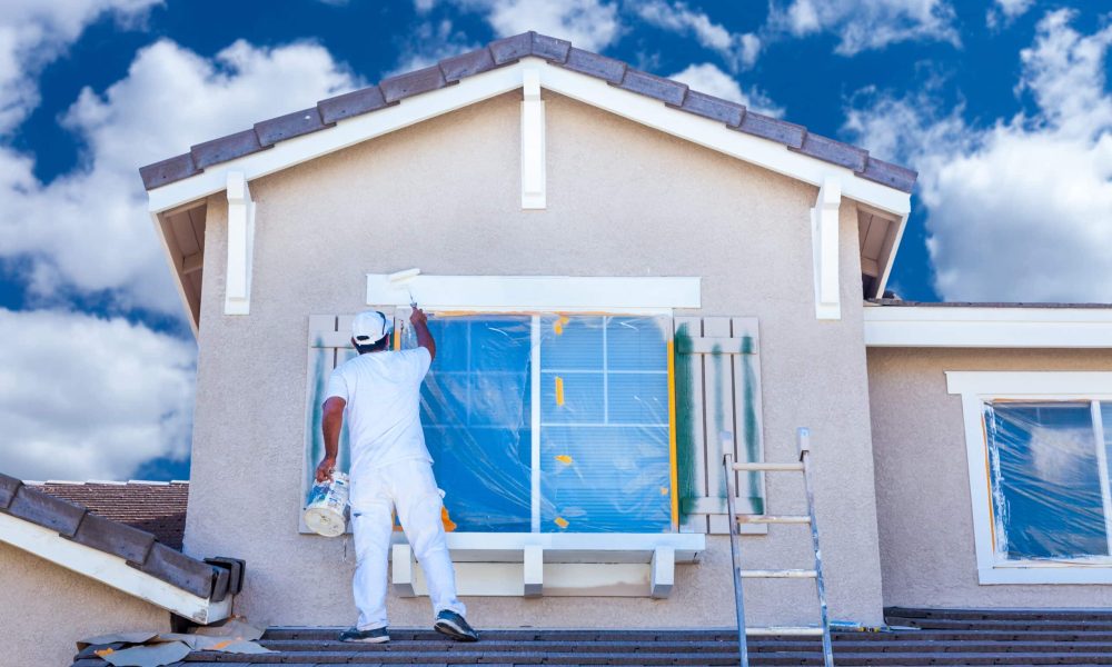 Professional House Painter Painting the Trim And Shutters of A Home.